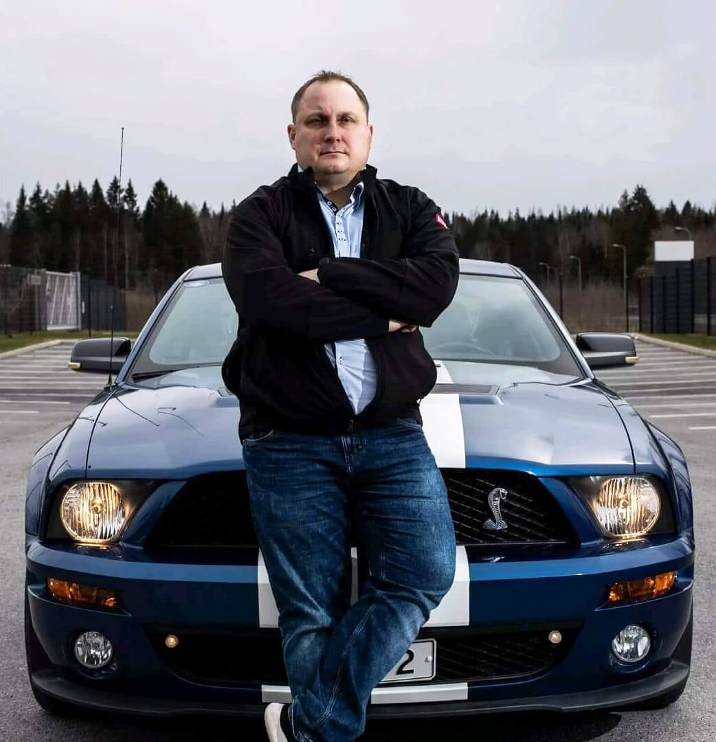 Jarno Lahnalahti nojaa Ford Mustang Shelby urheiluautoon.
